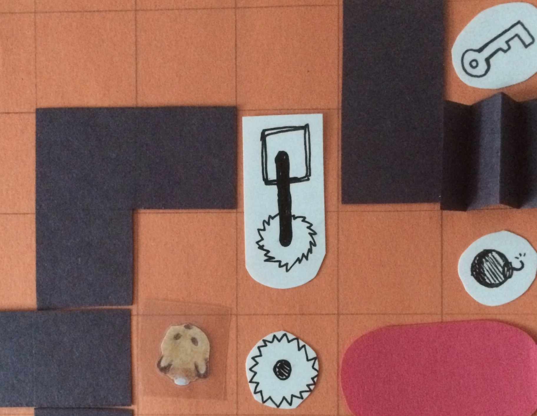 Paper prototype of a King Rabbit level with cut-out characters and traps